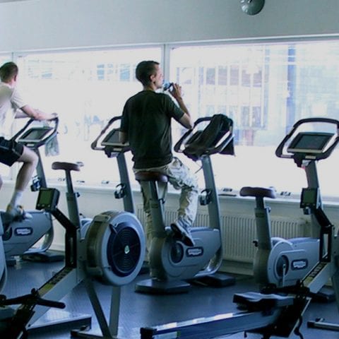 individuals using various pieces of gym equipment