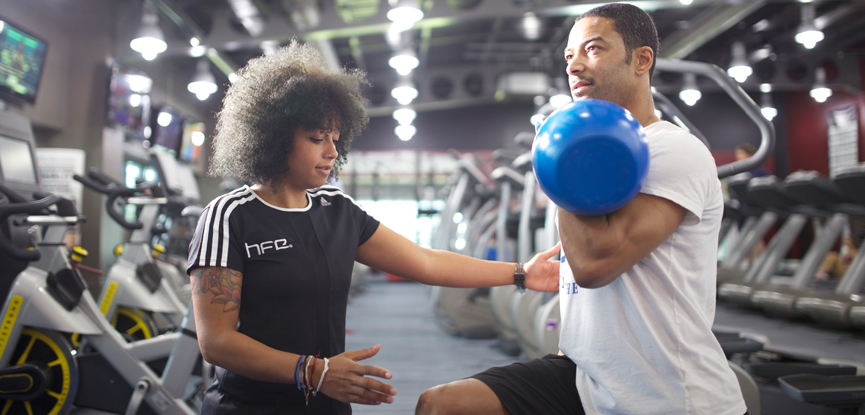 Personal trainer working with a client using a kettlebell