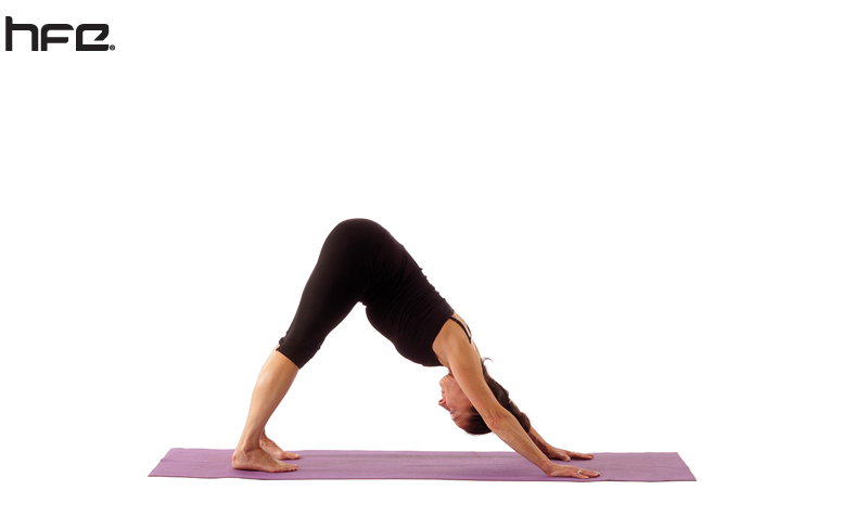 A female yoga instructor performing the downward-facing dog pose