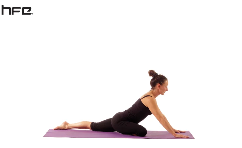 A female yoga teacher performing a pigeon pose