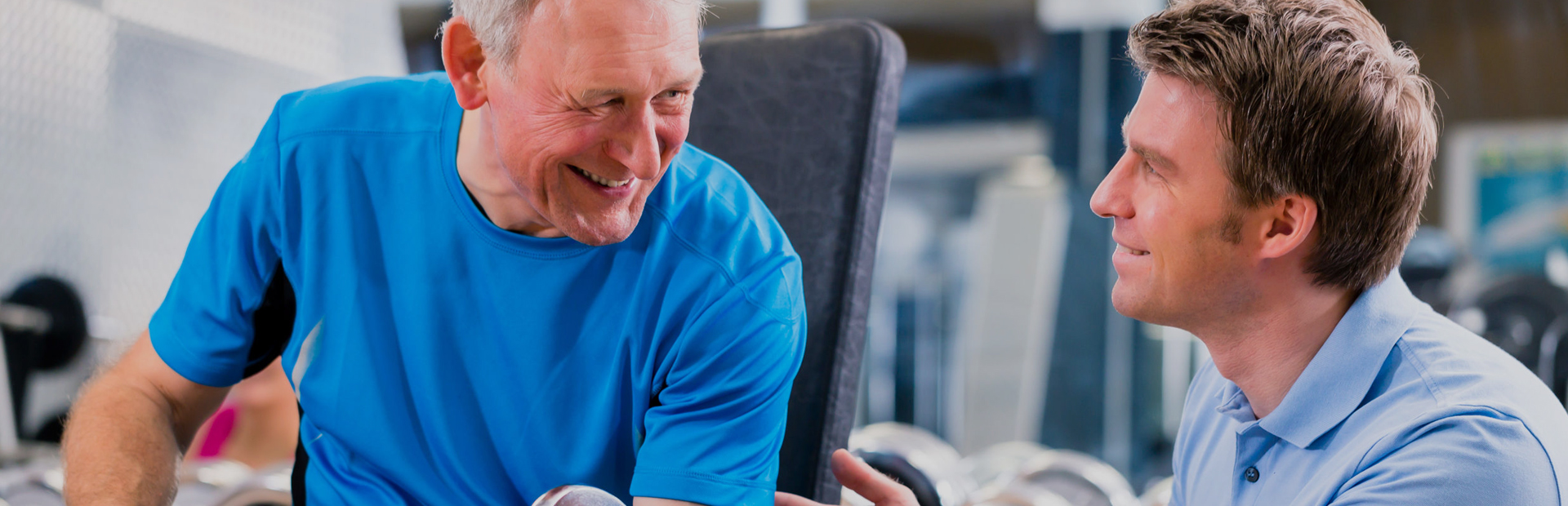 Fitness trainer working with an elderly client