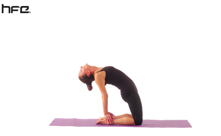 A yoga teacher performing a camel pose