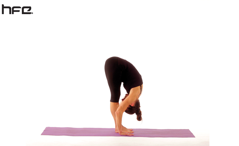 A yoga teacher performing an intense forward fold pose