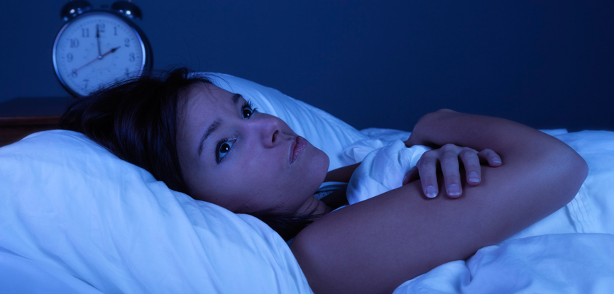 A woman lying in bed at night not sleeping