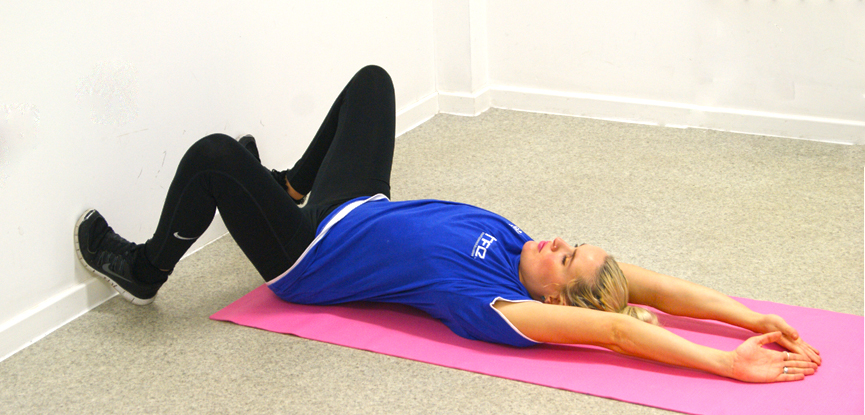 Support tutor Dani performs a supine wall squat