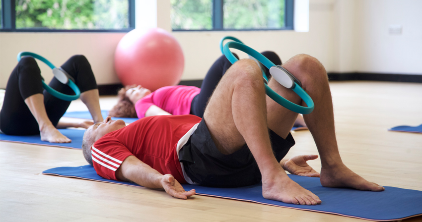 Pilates students performing exercises with a circle