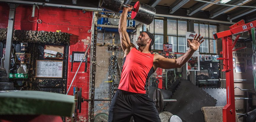 James Crossley performing a single arm raise with a heavy weight