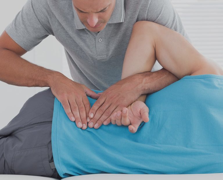 Sports massage therapist examining a client