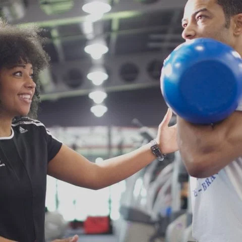 A qualified gym instructor working with a client