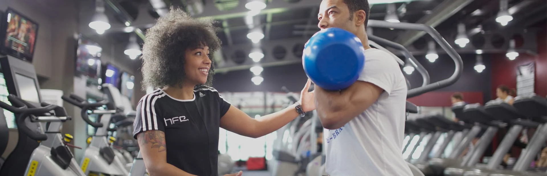 A qualified gym instructor working with a client