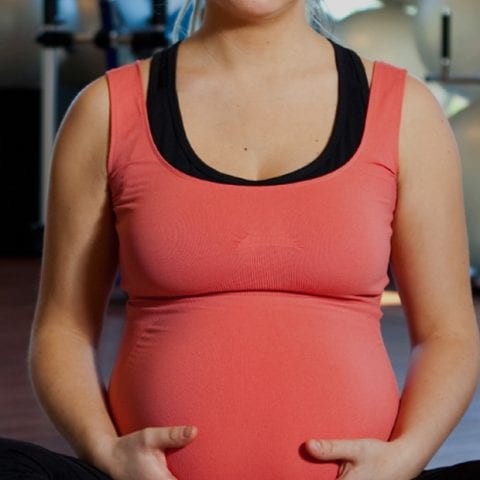 Pregnant client sitting in an exercise studio