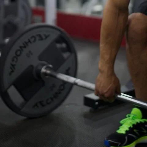 Personal trainer coaching a client through a deadlift