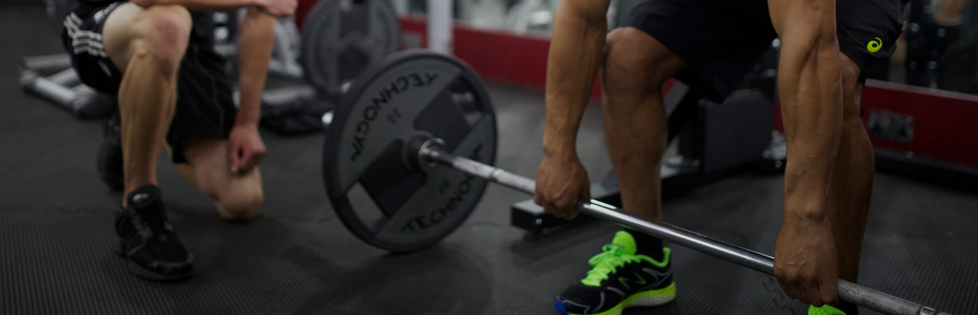 Personal trainer coaching a client through a deadlift