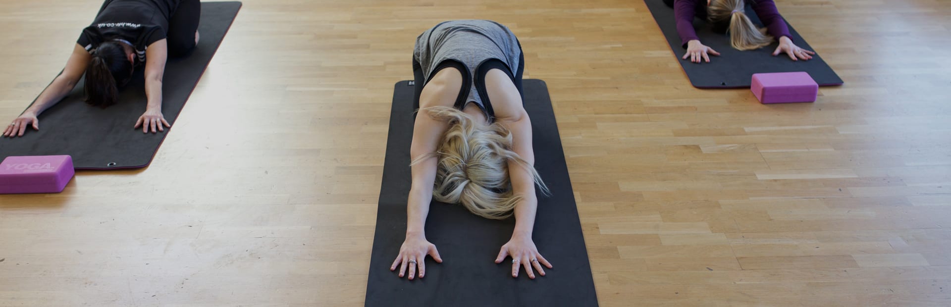 HFE yoga students performing Child's Pose