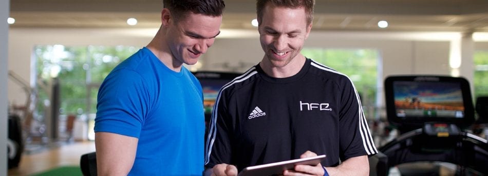 HFE tutor using an iPad with a student in a David Lloyd gym