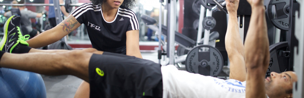 Personal trainer working with a client on the gym floor