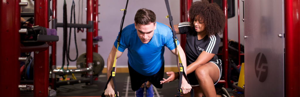 HFE personal trainer tutor working with a student on TRX