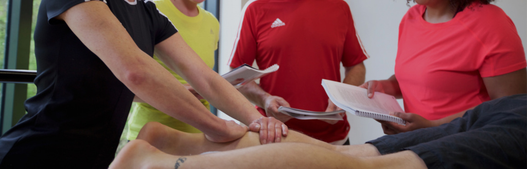 HFE sports massage tutor leads a hand-on session with students