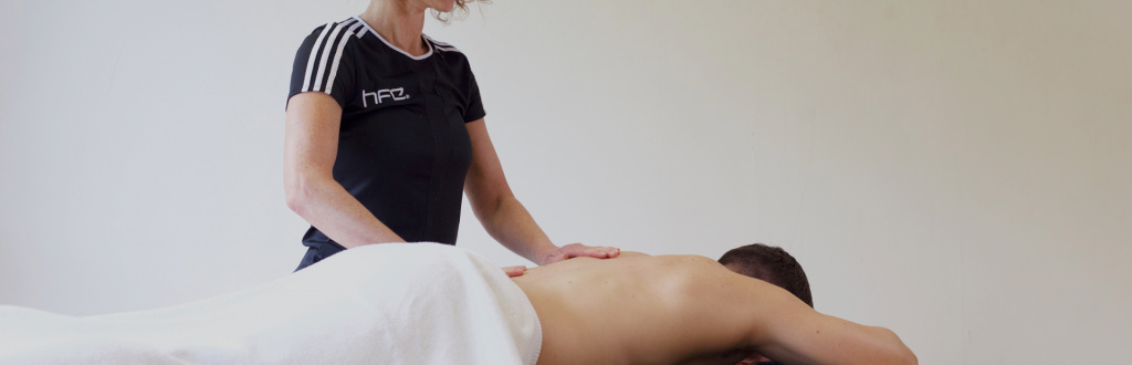 HFE qualified sports massage therapist working on a client