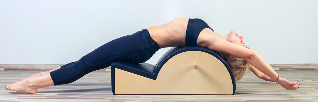 Pilates student using a spine corrector in a Pilates studio