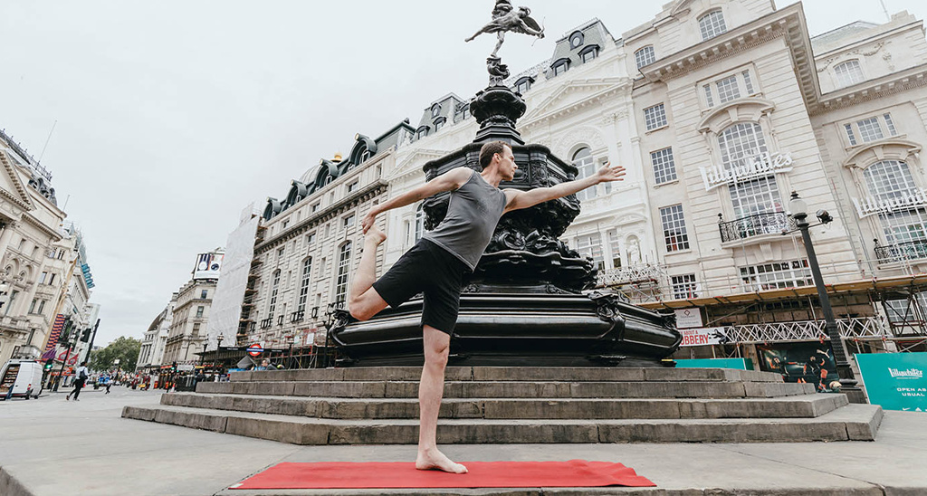 Creator of Yogibanker Scott Robinson performing the lord of the dance yoga pose