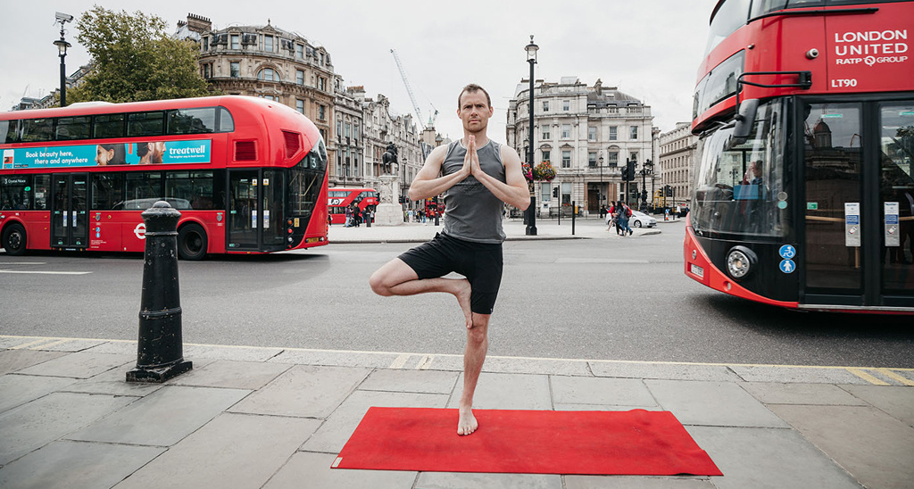 Creator of Yogibanker Scott Robinson performing the tree pose in London