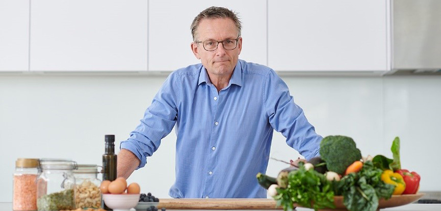 Dr Mosley posing in his kitchen