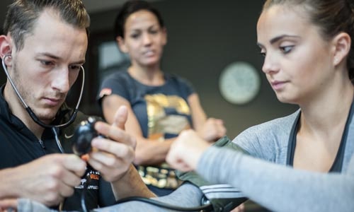 personal trainer reading blood pressure