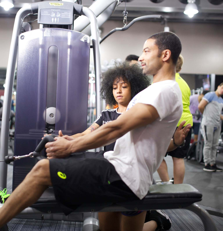 Woman in gym teaching seated row