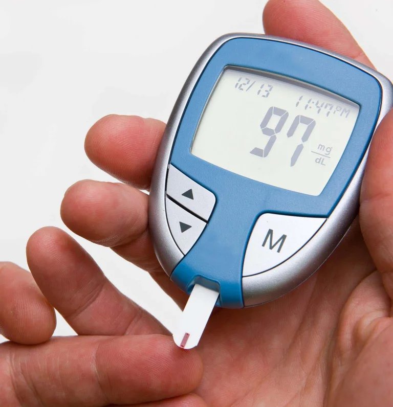 Person holding finger prick test to measure blood glucose for diabetes