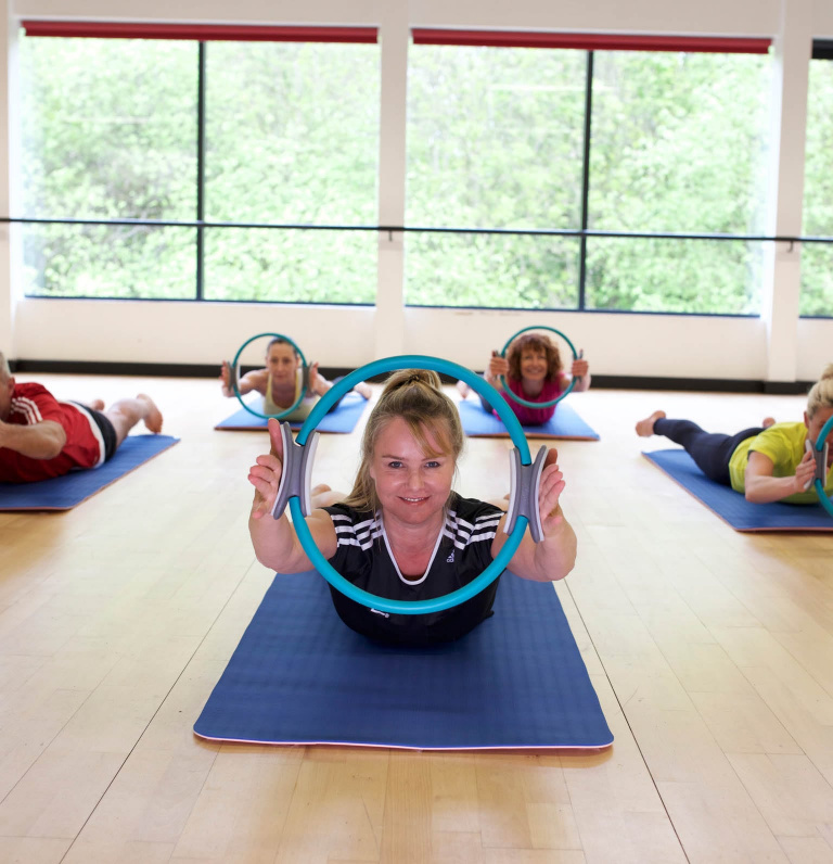 HFE Pilates teacher holding circle in Pilates class