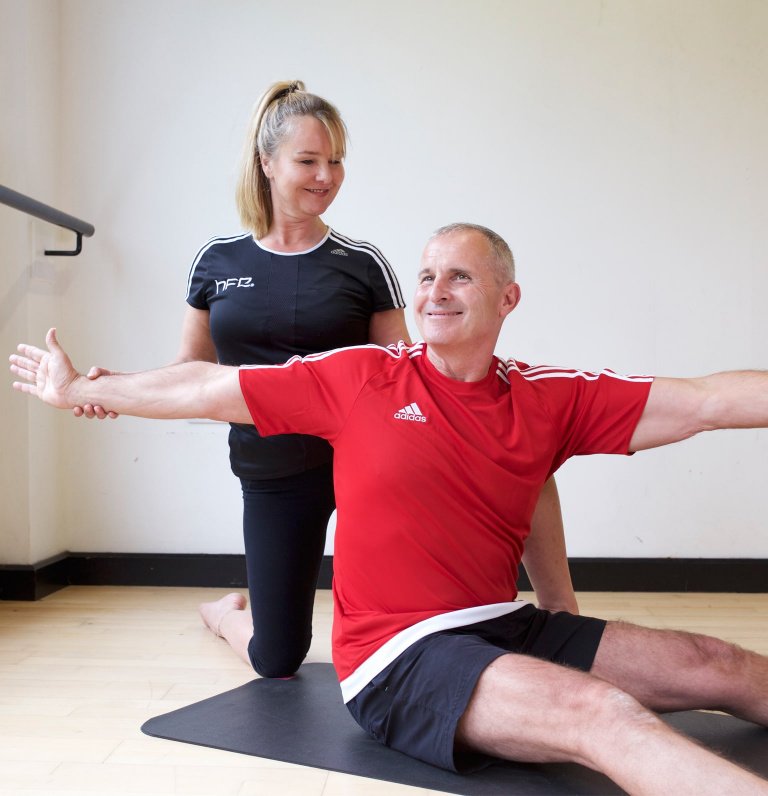 HFE Pilates instructor directing older adult client in class