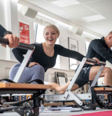 Pilates class member smiling on reformer
