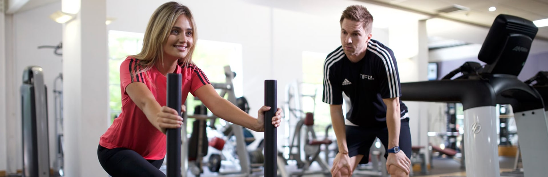 HFE personal trainer instructing client using prowler in gym