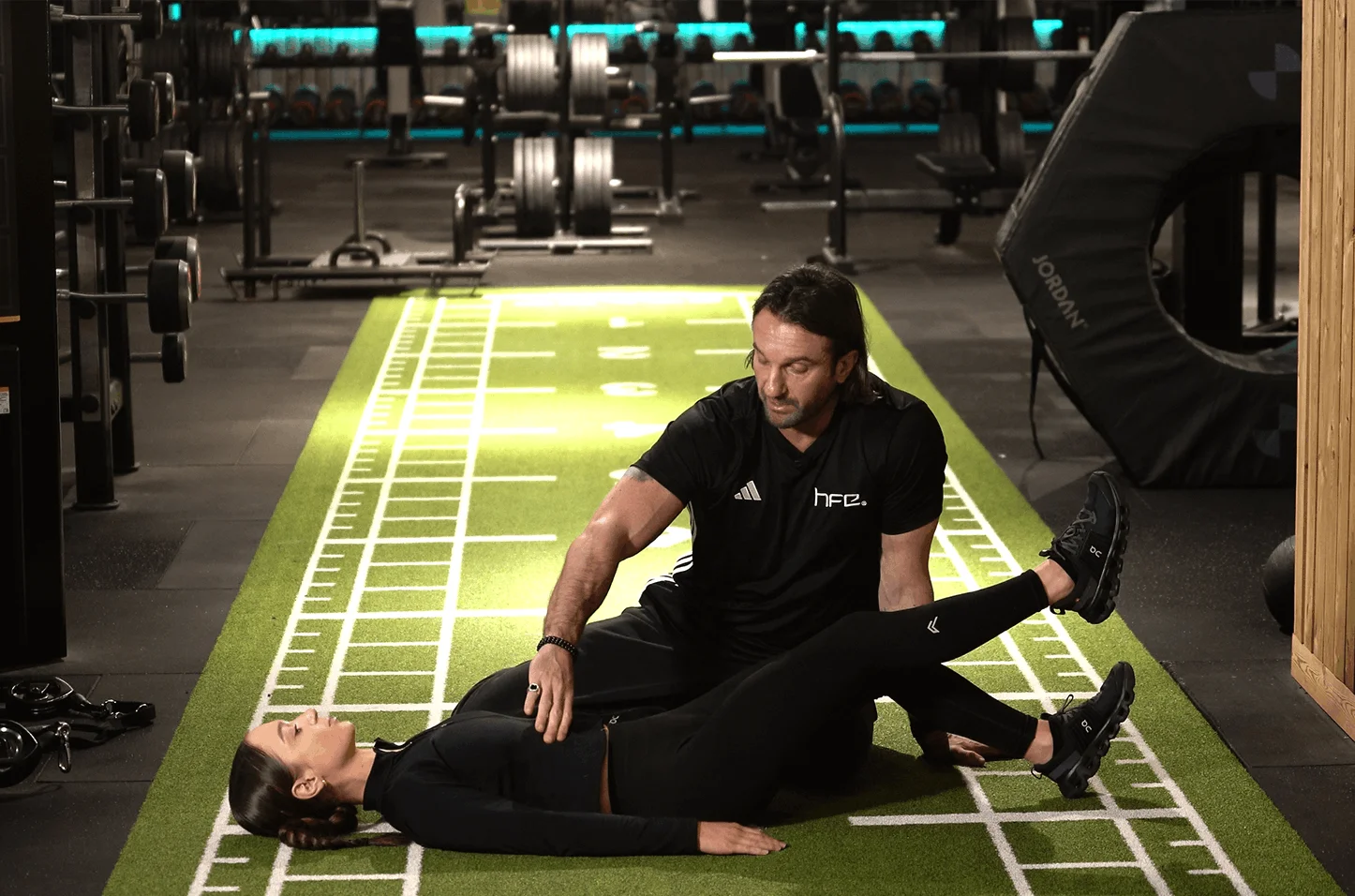 A personal trainer assisting a client on the gym floor