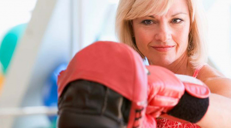 woman wearing boxing gloves in gym