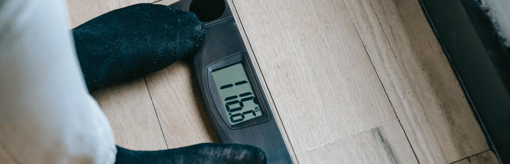 man weighing himself on scales