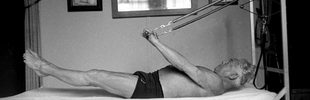 Joseph Pilates using an early version of the reformer