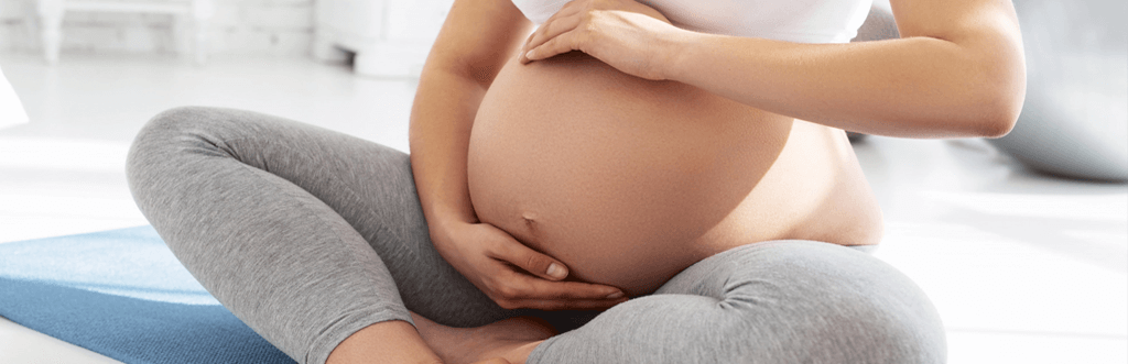 pregnant woman on yoga mat 