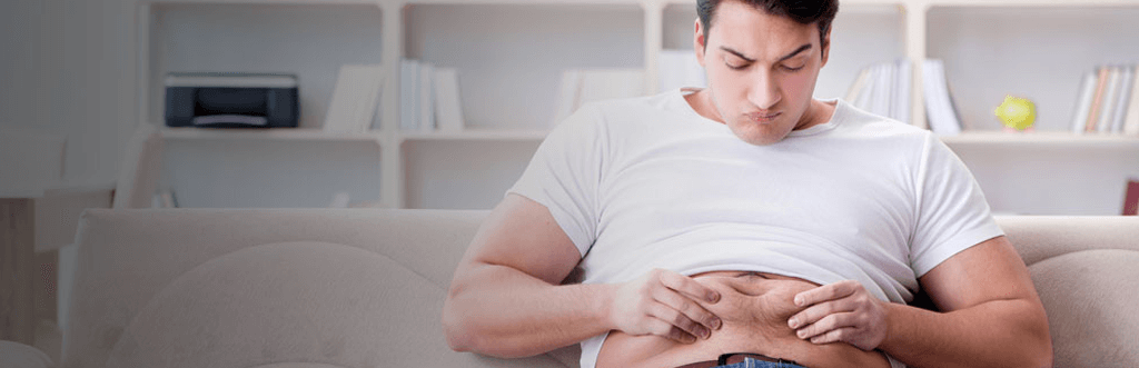 man pinching stomach fat