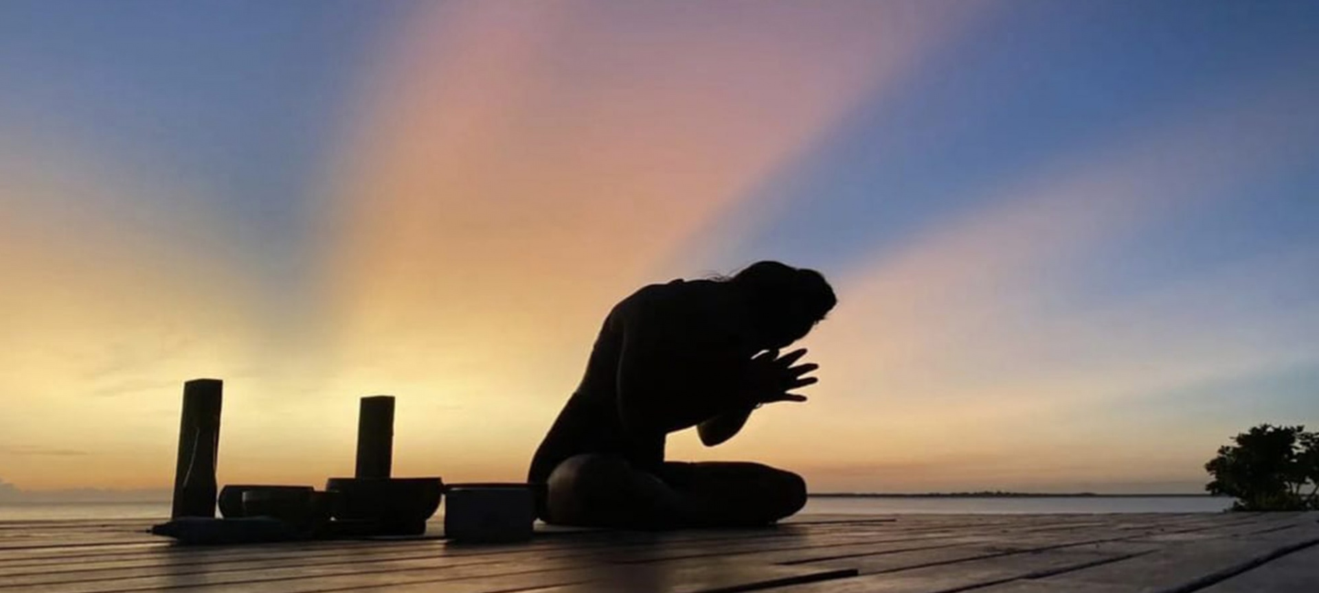 Zoe R - Yoga pose on deck with sunset background