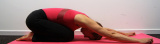 A person performing the Pilates shell stretch.