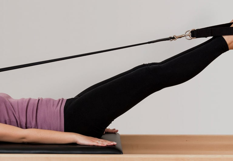 A HFE student performing Reformer Pilates.