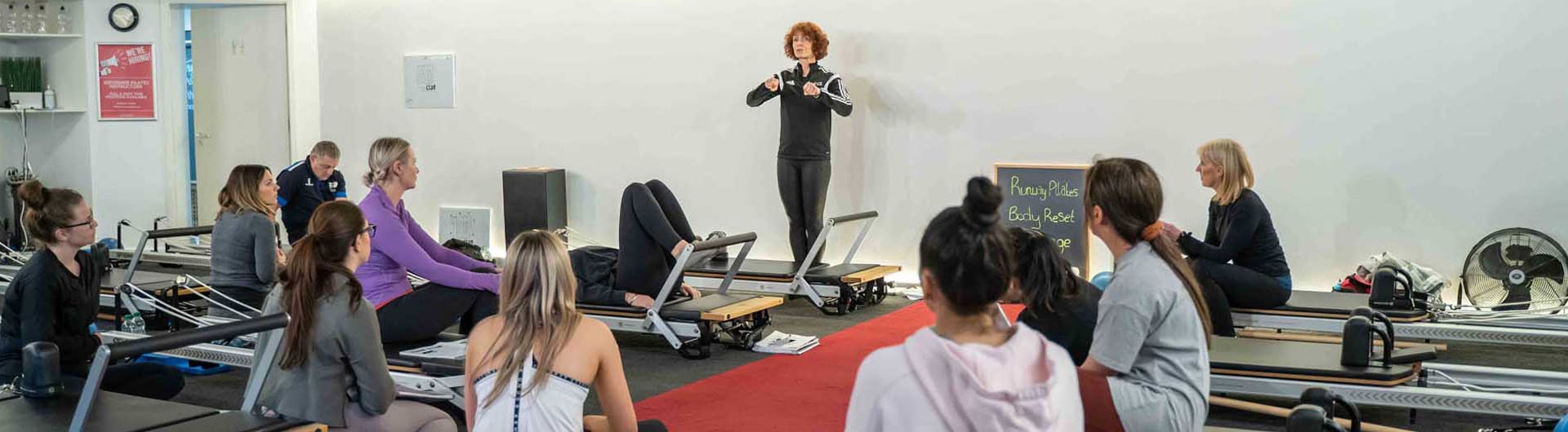 A HFE Pilates instructor talks to their reformer class.