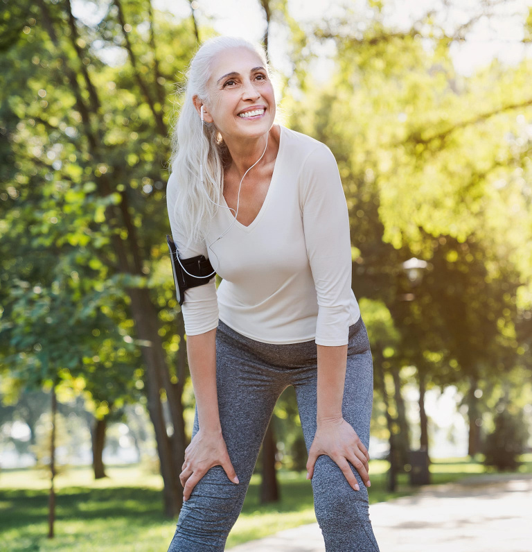female menopausal woman running in woods