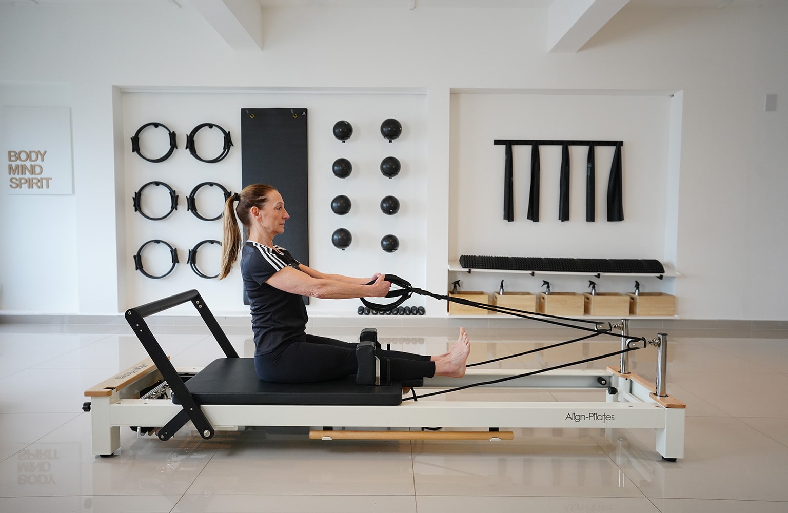 A reformer Pilates coach demonstrating how to use a reformer Pilates machine.