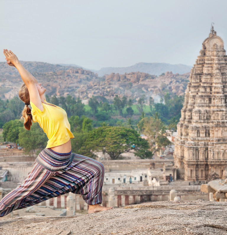 woman performing yoga in front of temple