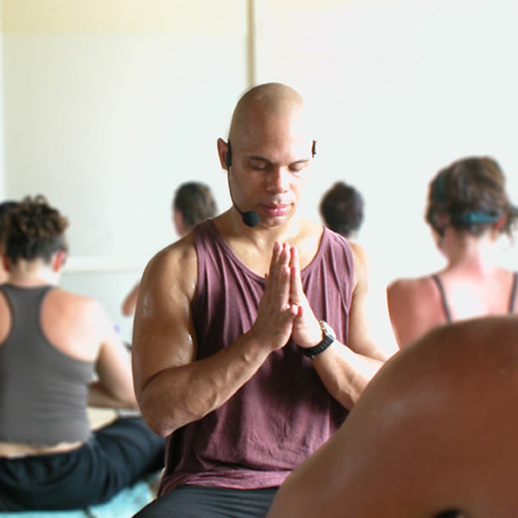 Rolf Gates teaching yoga with headset