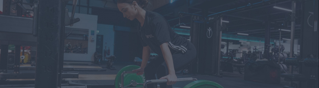 A female in a gym using the trap bar deadlift