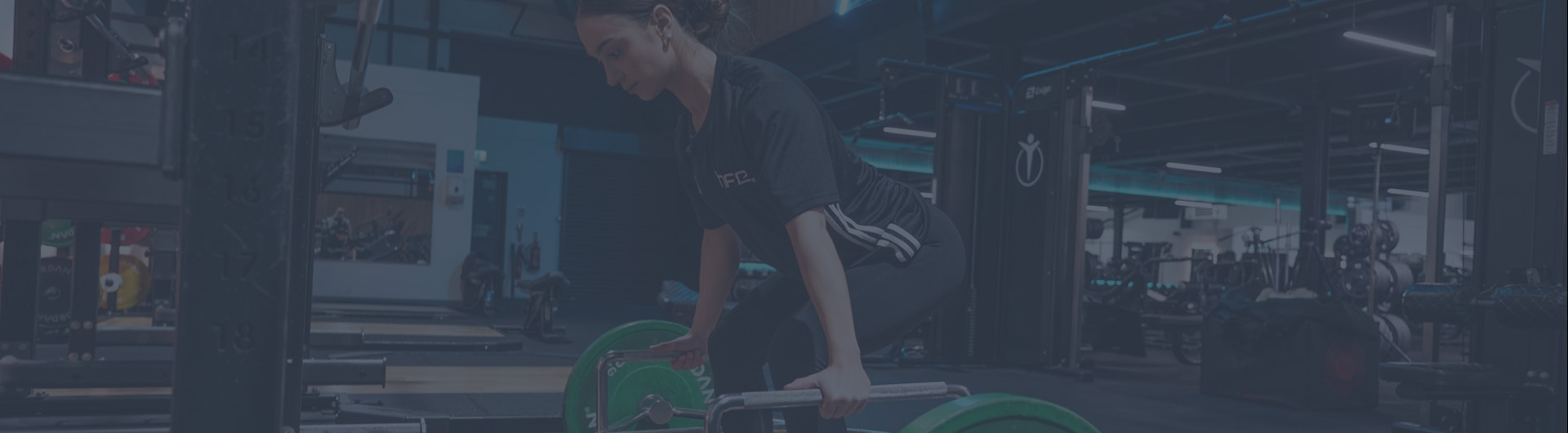 A female in a gym using the trap bar deadlift